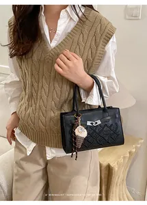 Chic black embroidered handbag with silver lock and a plush ice cream bag charm accessory