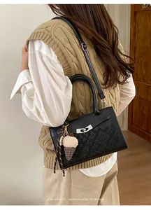 Detail of black embossed leather crossbody bag with ice cream charm and silver buckle