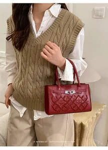 Detail of red quilted leather handbag with metallic turn-lock and retro stitching