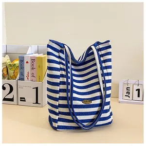 Detail shot of a blue and white striped canvas tote bag with a handmade tag