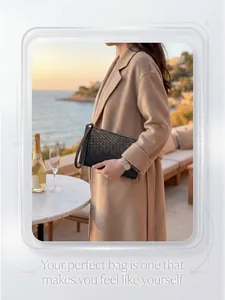 Close-up of a black woven leather clutch bag with zipper and wrist strap in outdoor setting