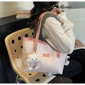 Detalle de bolso shopper rosa claro con bordado blanco y colgante de nube mullida