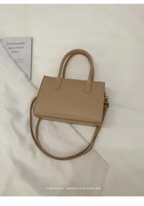 Detailed close-up of beige minimalist handbag with edge paint finish and smooth texture