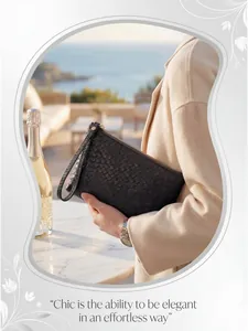 Close-up of black woven leather clutch bag with gold zipper and stylish wrist strap