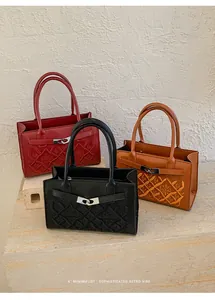 Detail of embroidered leather crossbody bags with metallic ring closures in three colors