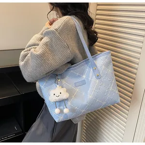 Detalle del bolso tote floral azul claro con colgante de nube y costuras blancas