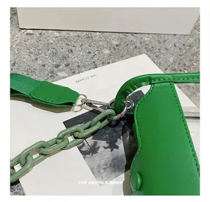 Close-up of emerald green bag showing silver metal swivel hooks and thick resin chain