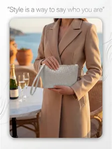 Silver woven texture clutch with wristlet held by a model in an elegant outdoor setting