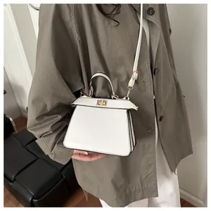 Detail der weißen Trapez-Tasche mit Metall-Drehverschluss und seitlichem Falten-Design