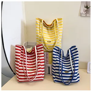 Close-up of colorful striped canvas tote bags in red, yellow and blue with fabric straps