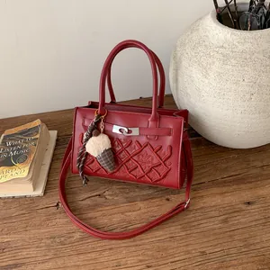 Deep red crossbody bag with diamond quilting, crown embroidery, and ice cream charm