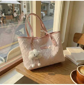 Detalle de bolso tote rosa en tejido jacquard con un lindo colgante de nube de peluche