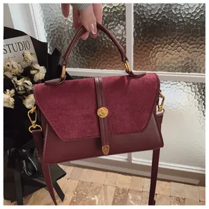 Detail der vintage burgunderroten Handtasche mit Samtklappe und goldener Schnalle für Damen