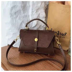 Detailansicht der braunen Retro-Handtasche mit Wildleder-Patchwork und goldener Schließe