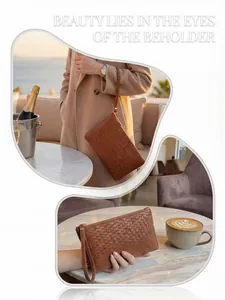 Detail of brown woven leather clutch featuring Intrecciato craft and gold zipper