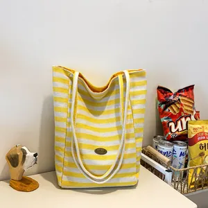 Fashionable large canvas tote bag with yellow and white stripes and handmade leather patch