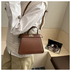 Detailansicht der braunen Leder-Trapeztasche mit metallischem Drehverschluss-Element