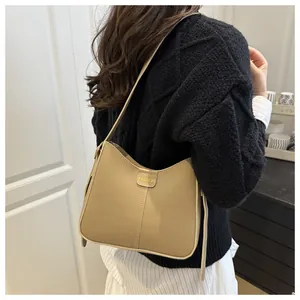 Detail view of khaki faux leather hobo bag with vertical stitching and fashion label