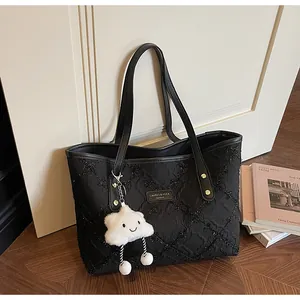 Detalle de bolso tote negro acolchado con lentejuelas y un lindo colgante de nube