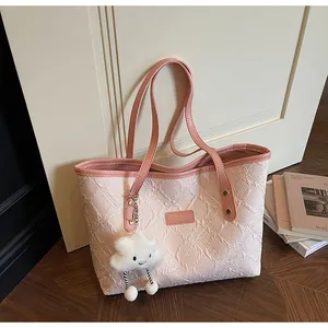 Detalle del bolso tote de tela rosa con etiqueta de cuero y colgante de nube