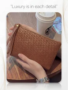 Detail of hand-woven texture on brown leather clutch bag in a cafe setting