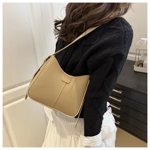 Close-up of khaki retro bucket bag with FASHION embossed label and textured finish