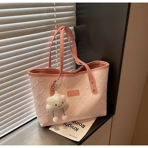 Detalle del bolso tote rosa y blanco con tela texturizada y asas de cuero en un alféizar de ventana