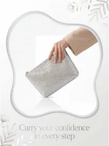 Close-up of silver woven texture clutch bag featuring high-quality golden zipper detail