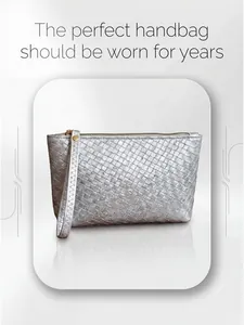 Detailed close-up of woven silver clutch purse with gold zipper and wristlet strap