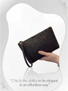 Detail of black leather woven clutch showing high-quality texture and gold zipper