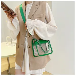 Detailed view of the clear PVC square bag with green leather trim and chunky plastic chain