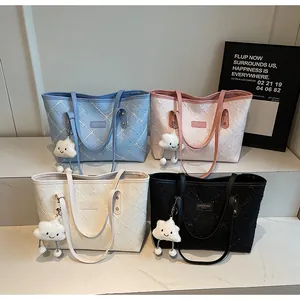 Detalle de cuatro bolsos tote grandes con texturas florales y colgantes de nubes