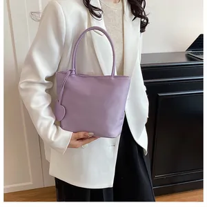 Detail of lavender satin tote bag with matching heart charm and smooth handles