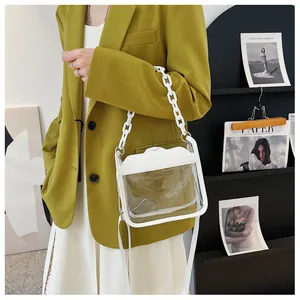 Chic clear crossbody bag with white chain handle and long strap worn over a green blazer