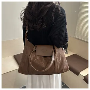 Nahaufnahme des braunen Strukturstoffs und des Logos dieser großen Reisetasche für Damen