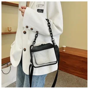 Detail of transparent PVC crossbody bag with black leather trim and chunky chain strap