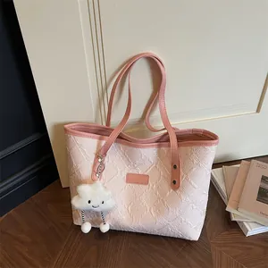 Bolso tote rosa con relieve floral y colgante de nube con correas largas de hombro