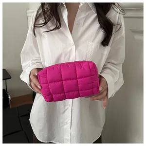 Detailed shot of quilted nylon toiletry bag in vibrant rose pink held by hand