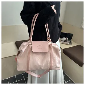 Dettaglio borsa da viaggio rosa chiaro con trama plissettata e tracolla regolabile