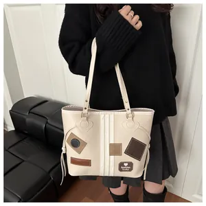 Detail shot of a cream PU tote bag with fashion lucky patches and vertical stripes