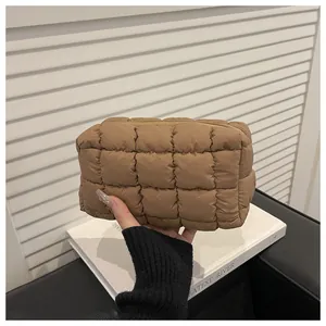 Detail of brown quilted nylon cosmetic bag with soft padded texture and smooth zipper