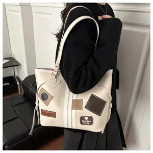 Detail of a vintage tote bag with decorative heart patches and stylish side drawstrings