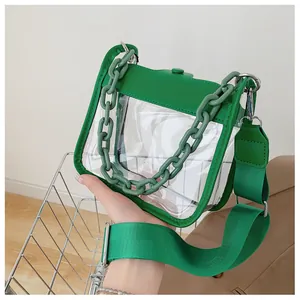 Detail of green transparent square bag with chunky chain and adjustable nylon strap