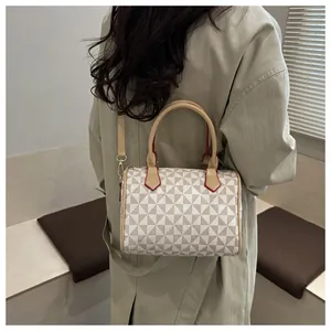 Détail du sac Boston montrant le motif géométrique et la bandoulière en cuir marron
