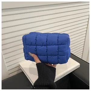 Detail of royal blue quilted nylon toiletry bag showing soft puffy texture and zipper