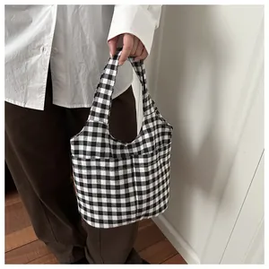 Detail shot of black and white gingham canvas tote bag featuring front utility pockets
