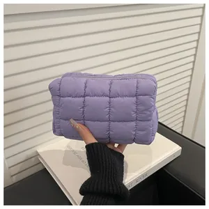 Close-up of quilted purple nylon makeup bag with a soft padded checkered texture and zipper
