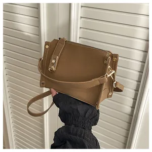 Vue détaillée du sac boîte marron montrant le fermoir doré et la texture du cuir