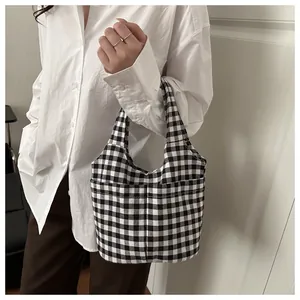 Detail shot of black and white checkered canvas tote bag with front pockets and sturdy handles