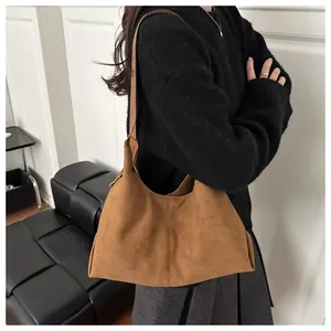 Detail einer braunen Wildleder-Hobo-Tasche mit matter Textur und vertikaler Steppnaht-Optik